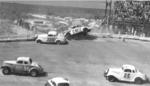 Red Farmer #C-97 nearly goes over the retaining barrier in the North Turn after an pile up in the 1956 Modified-Sportsman race..