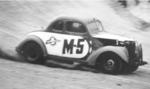 Speedy Thompson pitches his #M-5 Fish Carburetor Ford into the North Turn en route to victory in the 1955 Sportsman race...