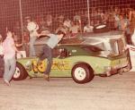 Ron McCreary stands on top of Eddie Parrett's hood as he climbs from his overturned car (Berry Collection)