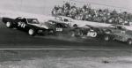 Johnny Doyle blows an engine and spins in front of the pack...