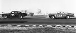 Jim Alvis leads Gordon Lee past a spinning car...