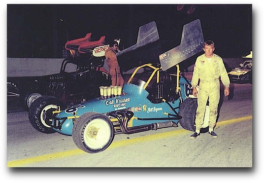 Bill Roynon with Cal Krusen's Sprinter - track unknown - Ollie Silva stands next to his car on the outside...