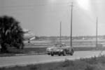 1962 race winning Ferrari passes a Corvette and a parked airplane in 1962 (Courtesy barcboys.com)