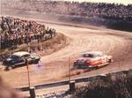 Buck Baker and Joe Guide, Jr. churn up the sand as they plow through the north turn during the 1954 Grand National.